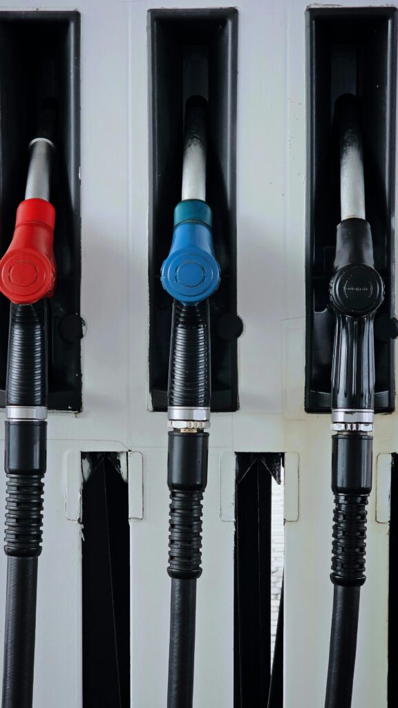 Close-up of multicolored fuel pumps at a gas station, showcasing different types of fuel.